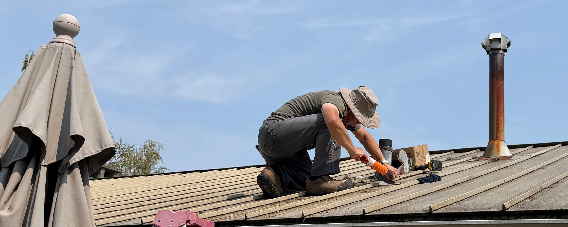 Handyman sealing a roof detail during a leak repair.
