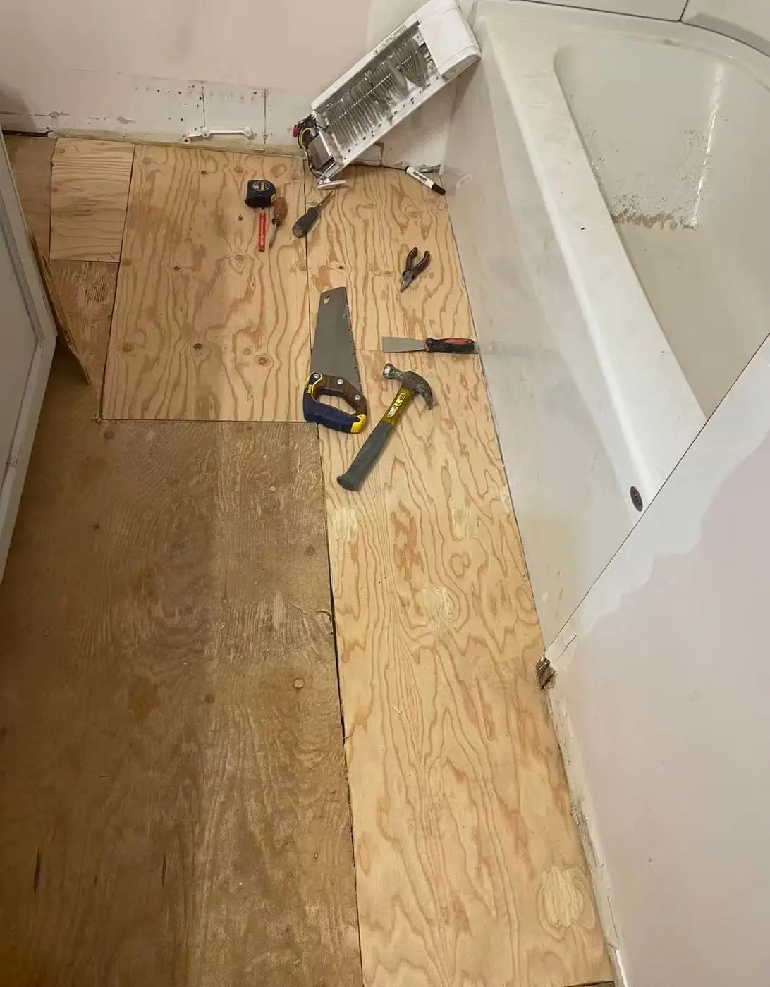 Finished floor up, damage visible along the tub edge.