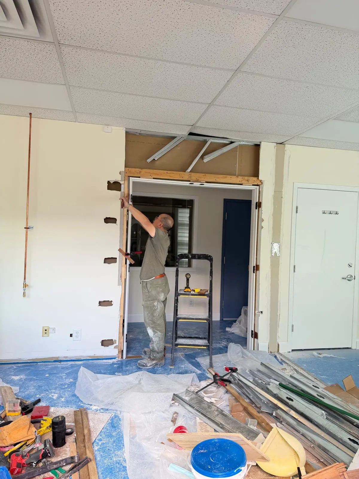 Checking the opening and jamb while the pair of doors was being fitted.